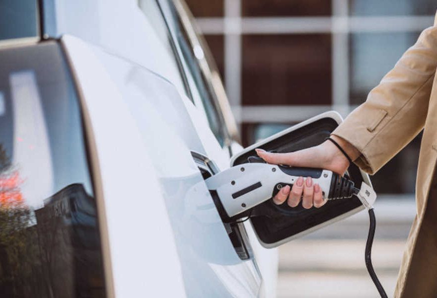 Mujer cargando coche eléctrico